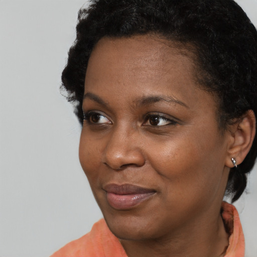 Joyful black young-adult female with short  black hair and brown eyes