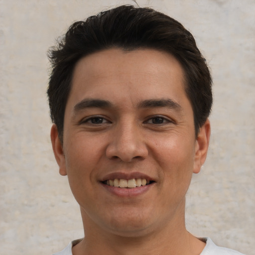 Joyful white young-adult male with short  black hair and brown eyes