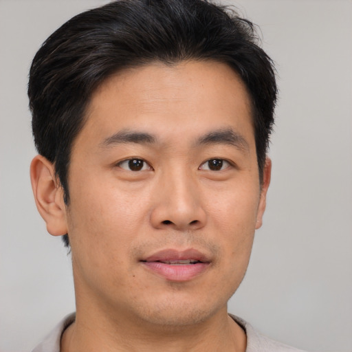 Joyful asian young-adult male with short  brown hair and brown eyes