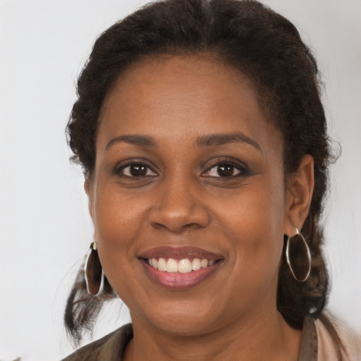 Joyful black young-adult female with long  brown hair and brown eyes