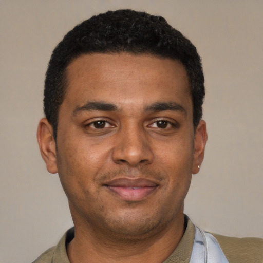 Joyful black young-adult male with short  black hair and brown eyes