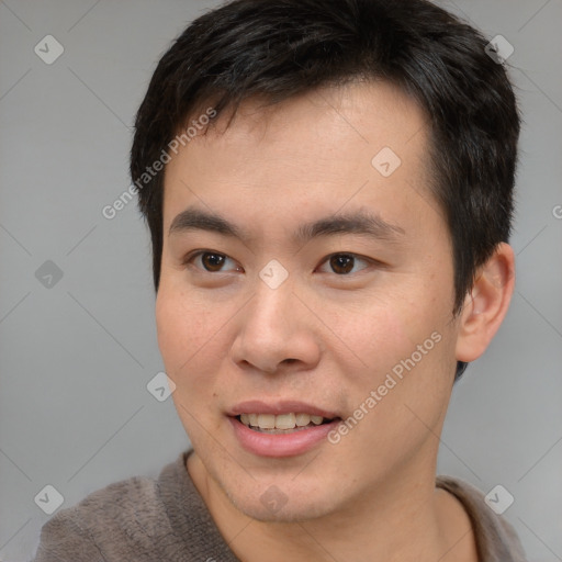 Joyful asian young-adult male with short  brown hair and brown eyes