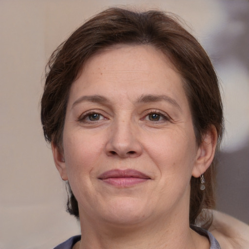 Joyful white adult female with medium  brown hair and brown eyes