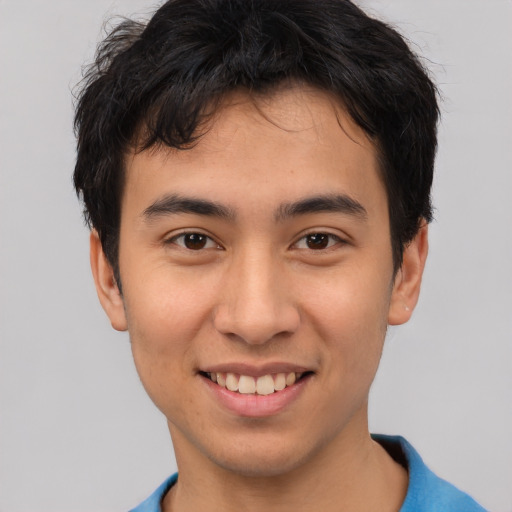 Joyful latino young-adult male with short  brown hair and brown eyes