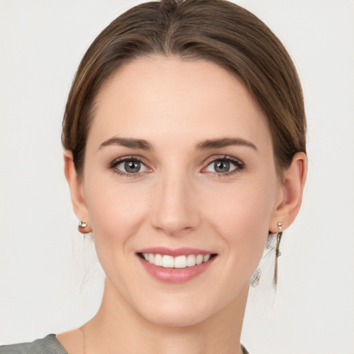 Joyful white young-adult female with medium  brown hair and grey eyes