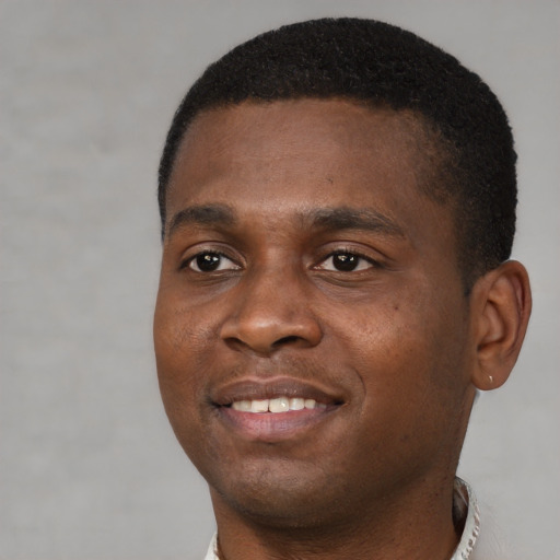 Joyful black young-adult male with short  brown hair and brown eyes