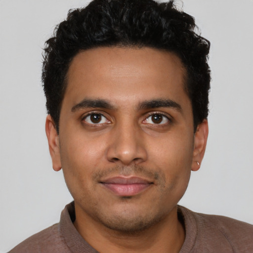 Joyful latino young-adult male with short  black hair and brown eyes