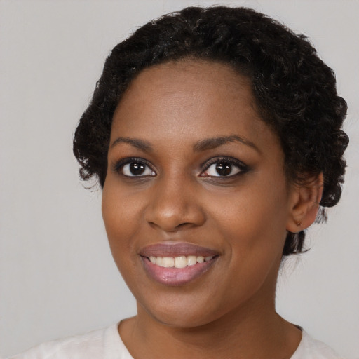 Joyful black young-adult female with short  black hair and brown eyes