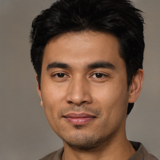 Joyful asian young-adult male with short  black hair and brown eyes