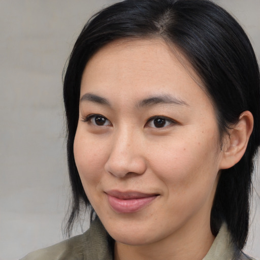 Joyful asian young-adult female with medium  brown hair and brown eyes