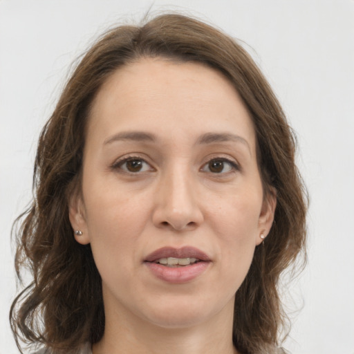 Joyful white adult female with medium  brown hair and green eyes