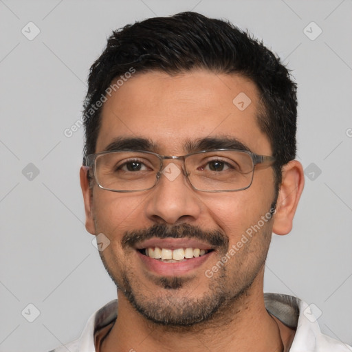 Joyful white adult male with short  black hair and brown eyes