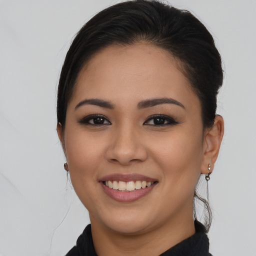 Joyful latino young-adult female with long  brown hair and brown eyes