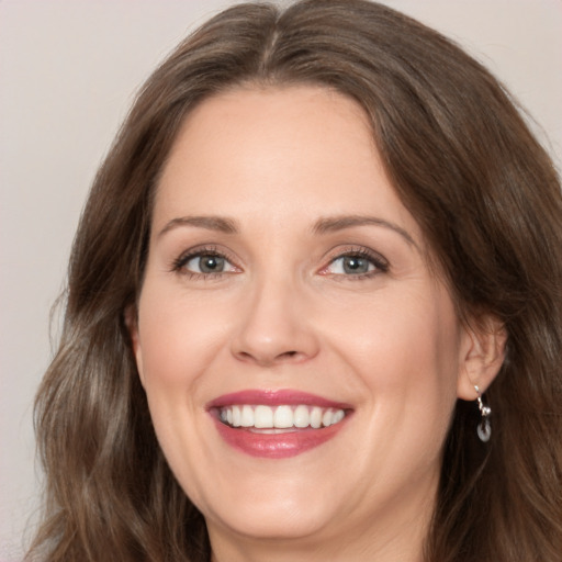 Joyful white adult female with long  brown hair and brown eyes