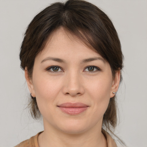 Joyful white young-adult female with medium  brown hair and grey eyes