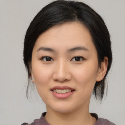 Joyful asian young-adult female with medium  black hair and brown eyes