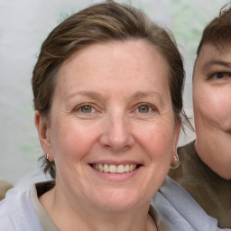 Joyful white adult female with medium  brown hair and blue eyes