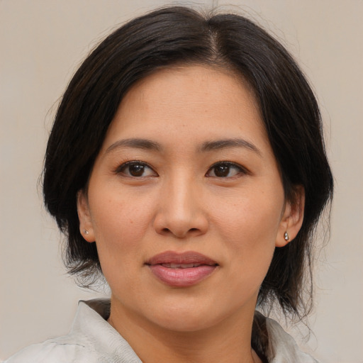Joyful asian adult female with medium  brown hair and brown eyes