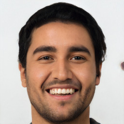 Joyful latino young-adult male with short  black hair and brown eyes