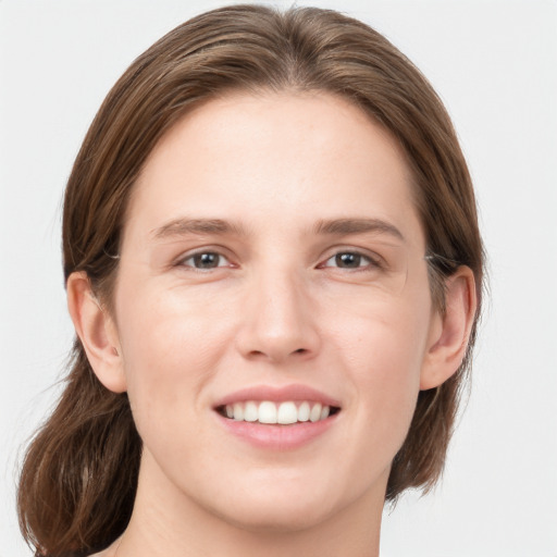 Joyful white young-adult female with medium  brown hair and grey eyes