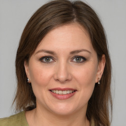 Joyful white adult female with medium  brown hair and grey eyes