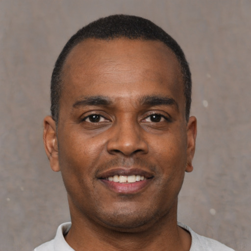 Joyful black young-adult male with short  brown hair and brown eyes