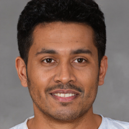Joyful latino young-adult male with short  black hair and brown eyes