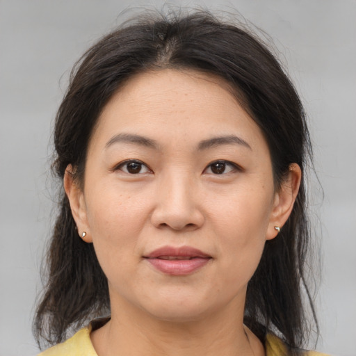 Joyful asian adult female with medium  brown hair and brown eyes