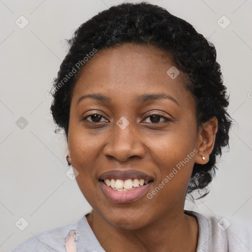 Joyful black young-adult female with short  black hair and brown eyes