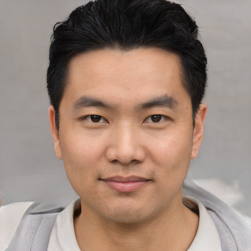 Joyful asian young-adult male with short  black hair and brown eyes