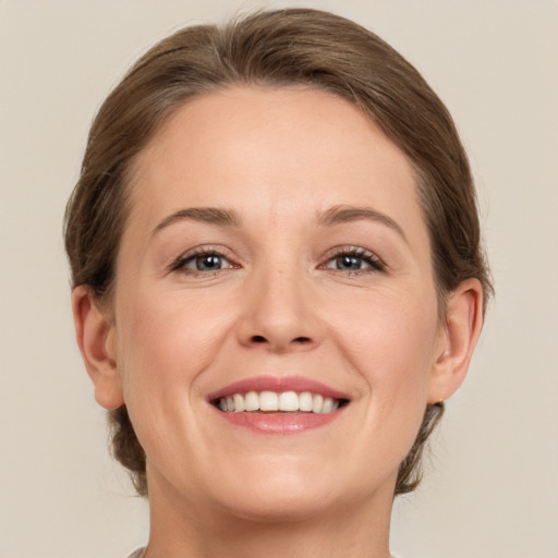 Joyful white adult female with medium  brown hair and grey eyes