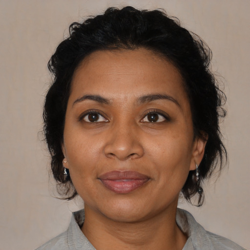 Joyful latino adult female with medium  brown hair and brown eyes