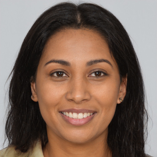 Joyful latino young-adult female with long  brown hair and brown eyes