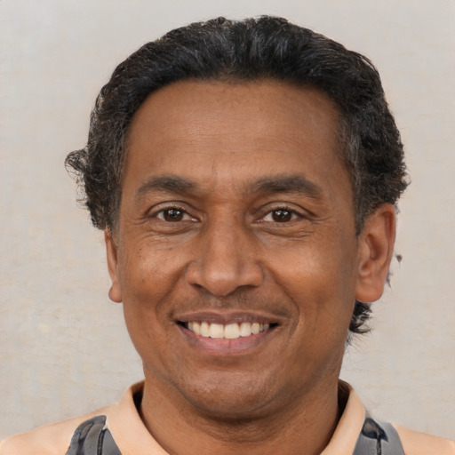 Joyful latino adult male with short  black hair and brown eyes