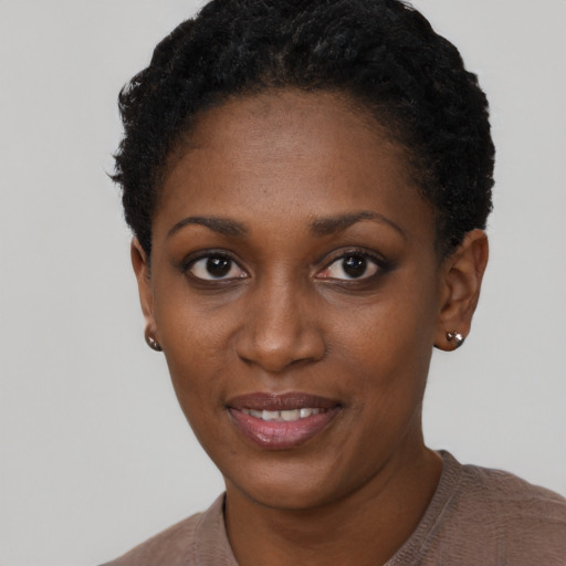 Joyful black young-adult female with short  black hair and brown eyes