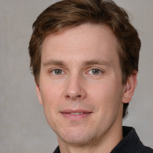 Joyful white adult male with short  brown hair and grey eyes