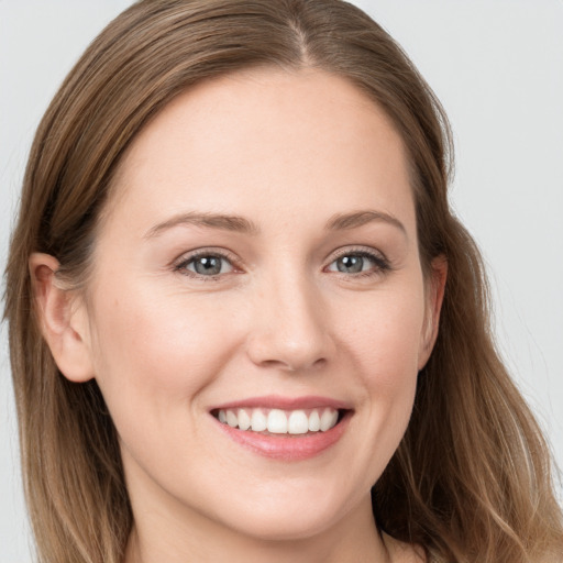 Joyful white young-adult female with long  brown hair and grey eyes