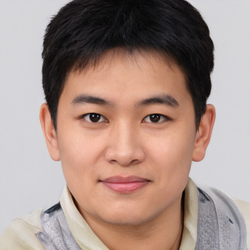 Joyful asian young-adult male with short  black hair and brown eyes