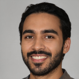 Joyful latino young-adult male with short  black hair and brown eyes