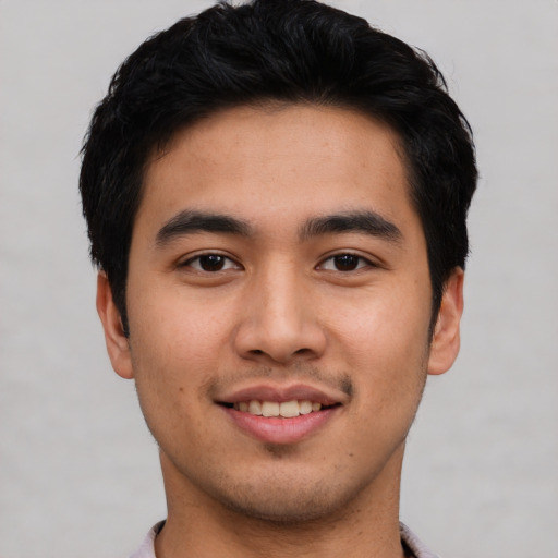 Joyful asian young-adult male with short  black hair and brown eyes