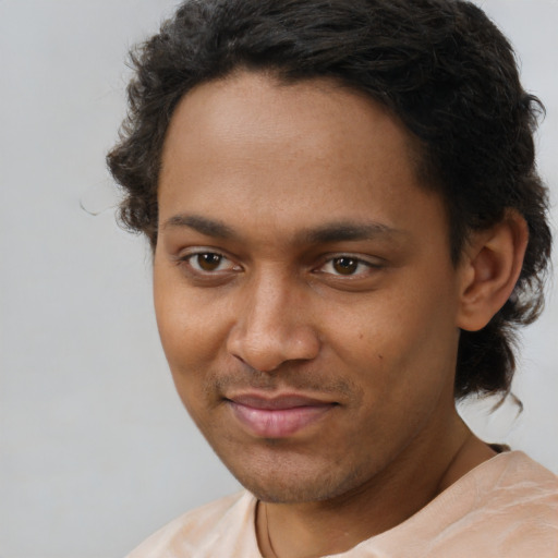 Joyful black young-adult male with short  brown hair and brown eyes