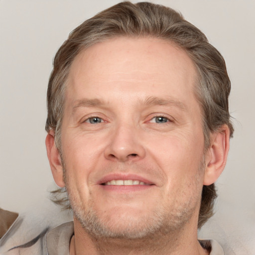 Joyful white adult male with short  brown hair and grey eyes