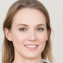 Joyful white young-adult female with long  brown hair and blue eyes