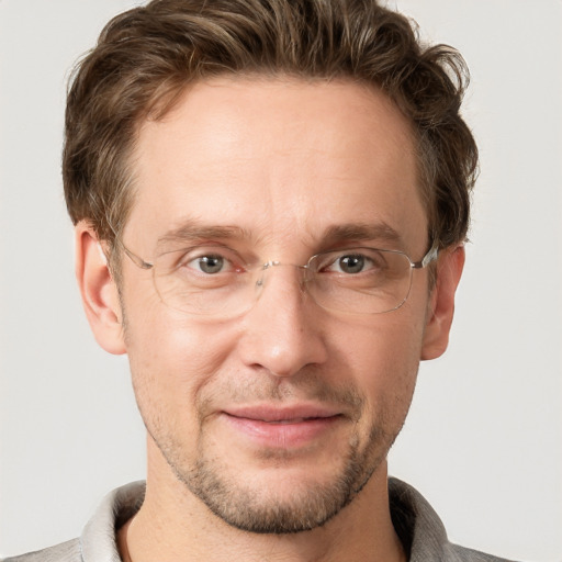 Joyful white adult male with short  brown hair and grey eyes