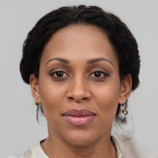 Joyful black adult female with medium  brown hair and brown eyes
