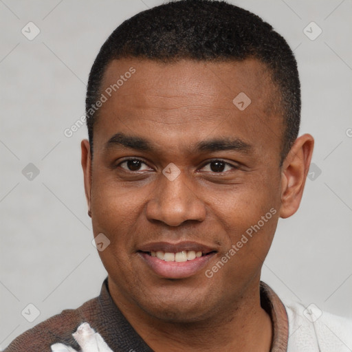 Joyful black young-adult male with short  brown hair and brown eyes