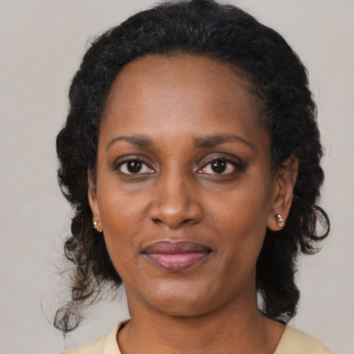 Joyful black young-adult female with medium  black hair and brown eyes