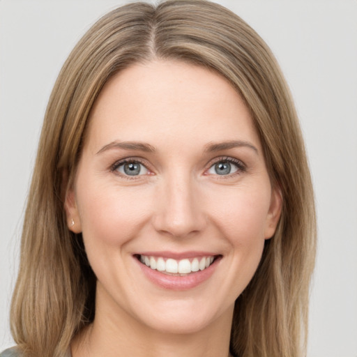 Joyful white young-adult female with long  brown hair and green eyes