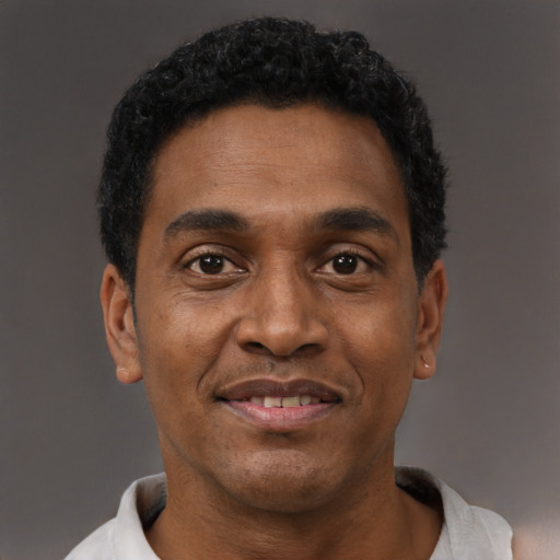 Joyful black adult male with short  black hair and brown eyes