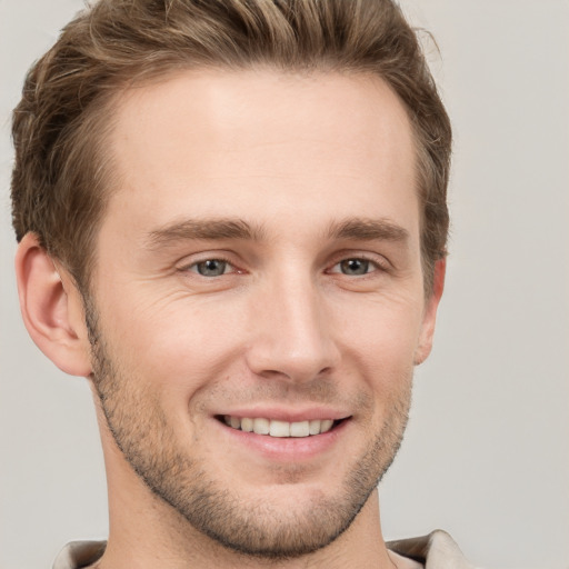 Joyful white young-adult male with short  brown hair and grey eyes